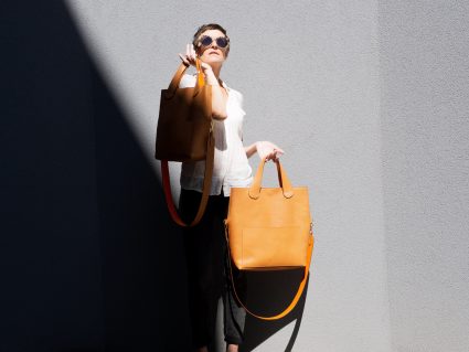 modèle féminin avec deux sacs à main orange
